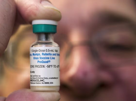Image: A pediatrician holds a dose of the measles-mumps-rubella vaccine