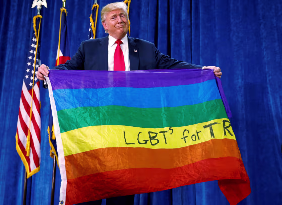 Image: Republican presidential nominee Donald Trump holds up a rainbow flag with \"LGBT's for TRUMP\" written on it at a campaign rally in Greeley