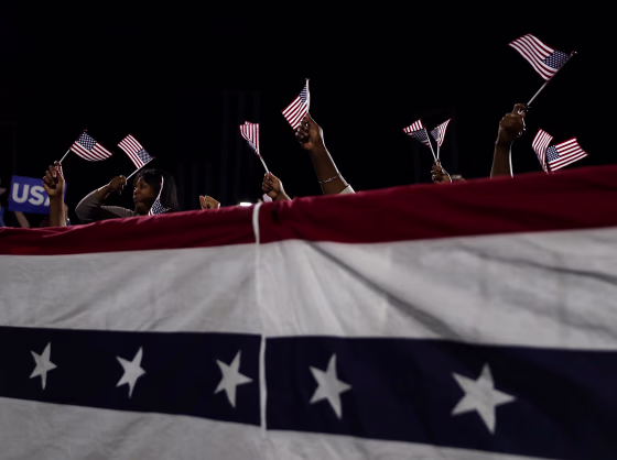 Image: Supporters hold American flags at a rally for Hillary Clinton