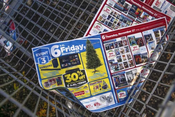 Black Friday advertisements are seen in the bottom of a shopping cart outside a shopping area in Westbury, New York