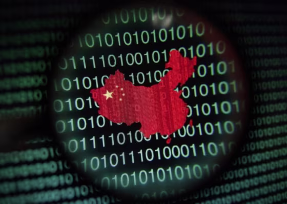 A map of China is seen through a magnifying glass on a computer screen showing binary digits in Singapore