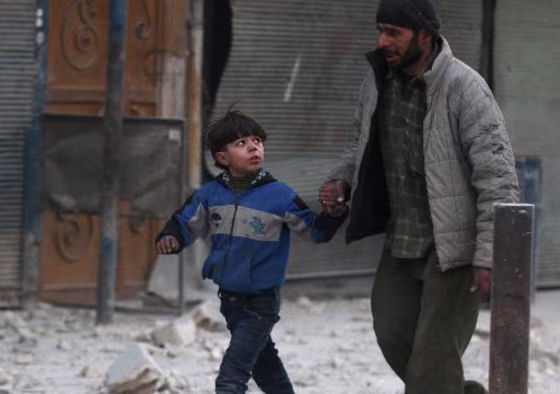 Image: A man holds the hand of a boy