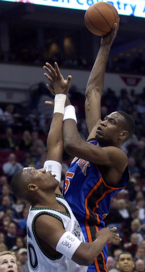 Image: Minnesota Timberwolves center Ervin Johnson, left, can't stop a shot by New York Knicks center Dikembe Mutombo