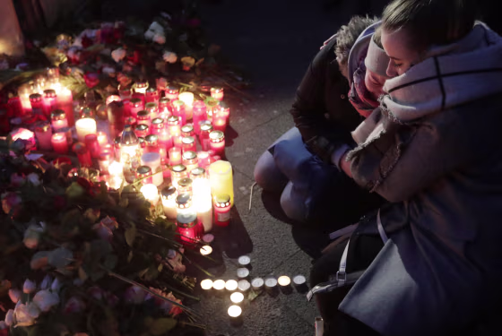 Image: Two women mourn beside candles in Berlin, Germany, Dec. 20, 2016, the day after a truck ran into a crowded Christmas market nearby and killed several people.