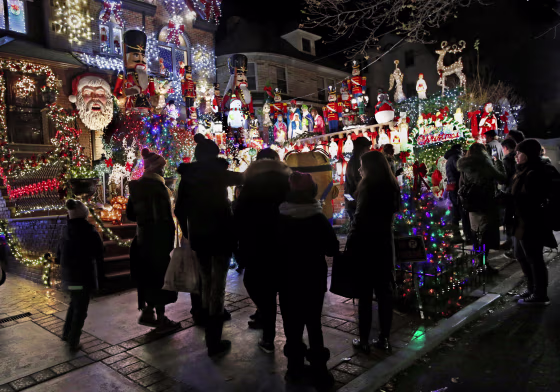 Image:In this Dec. 14, 2016 photo, visitors to the Dyker Heights neighborhood of the Brooklyn Borough of New York gather in front of Lucy Spata's house, as they tour the area known for it's elaborate and over-the-top Christmas displays.