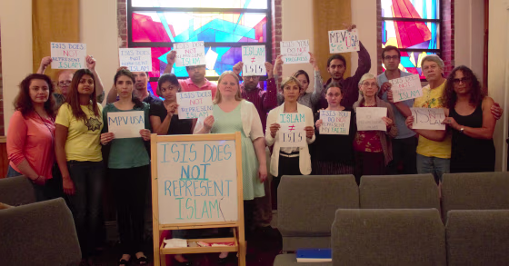 Attendees at a 2016 Muslim for Progressive Values event in New York holding signs stating that ISIS does not represent Islam.