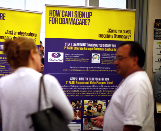 Image: FILE PHOTO - Julian Gomez explains Obamacare to people at a health insurance enrolment event in Commerce