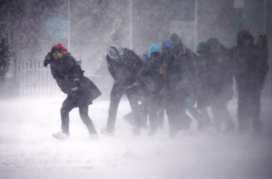 Image: People struggle to walk in the blowing snow during a winter storm in Boston