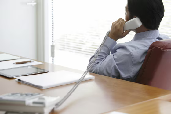 Mature businessman talking on phone in office