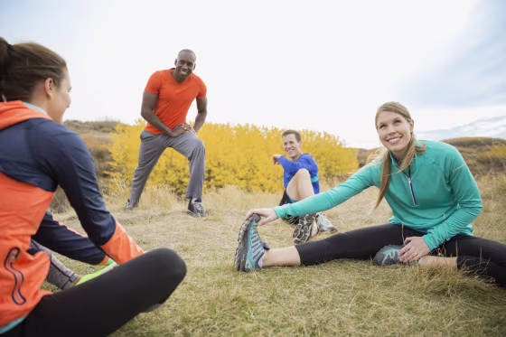 Runners stretching in field