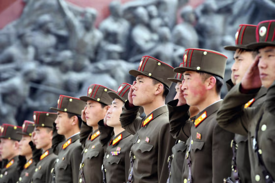 Image: North Korean soldiers salute bronze statues of North Korea's late founder Kim Il-sung and late leader Kim Jong Il at Mansudae in Pyongyang