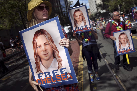 People hold signs calling for the release of Chelsea Manning while marching in a gay pride parade in San Francisco, California on June 28, 2015.
