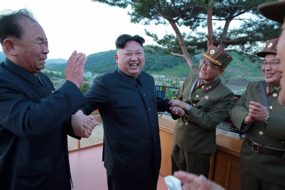 Image: North Korean leader Kim Jong Un reacts with members of the Korean People's Army scientists and engineers