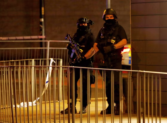 Image: Armed Police Stand Next to a Police Cordon Outside Manchester Arena