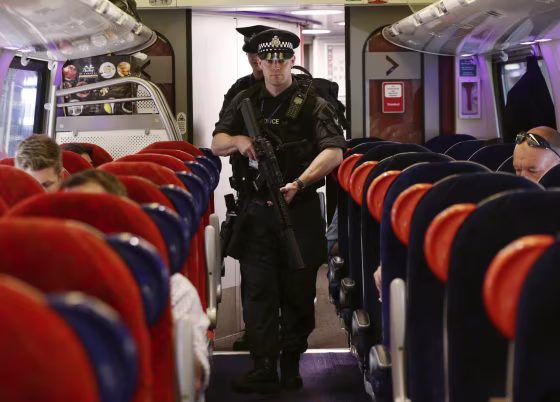 Image: Armed police patrol a train