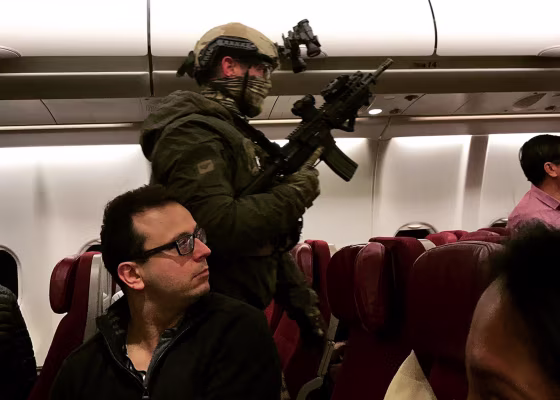 Image: An armed tactical officer sweeps a Malaysia Airlines flight at Melbourne Airport in Australia on Wednesday