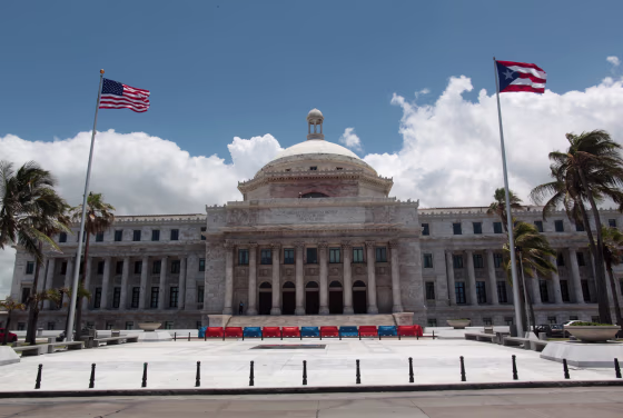Image: The flags of the U.S. and Puerto Rico fly outside the Capitol building in San Juan