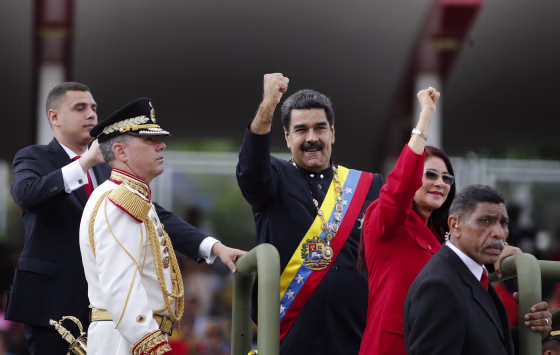 Image: Venezuela's President Nicolas Maduro and first lady Cilia Flores raise their fists during a military parade