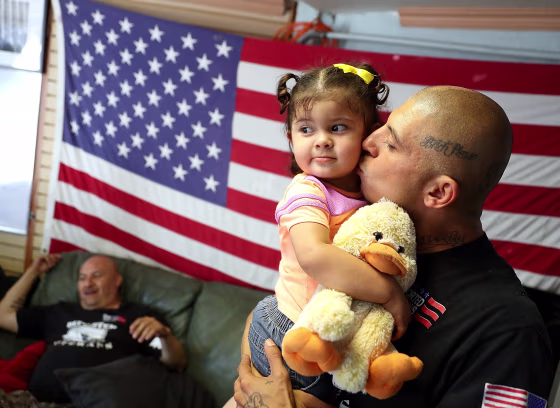 Image: A veteran kisses his daughter