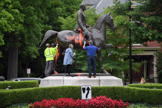 Image: Municipal workers attempt to remove paint from a monument dedicated to Confederate soldier John B. Castleman that was vandalized late Saturday night in Louisville