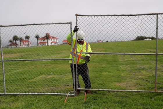 Image: A worker installs a fence at Crissy Field in anticipation of Saturday's Patriot Prayer rally and counter demonstration in San Francisco, California