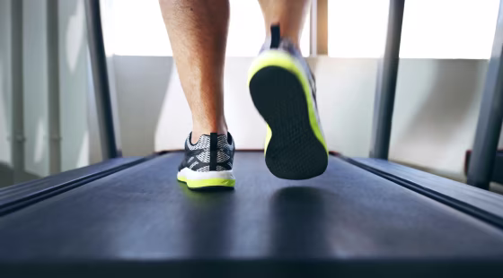 Image: A man walks on a treadmill in the gym