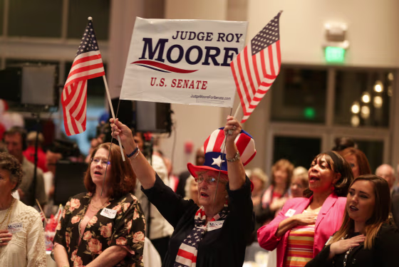 Image: A Republican Moore supporter stands for the national anthem during the runoff election for the Republican nomination for Alabama's U.S. Senate seat in Montgomery