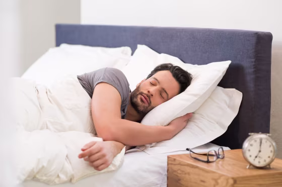 Image: A man sleeps in bed alone.