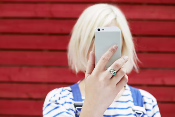 Image: woman holding up mobile for selfie