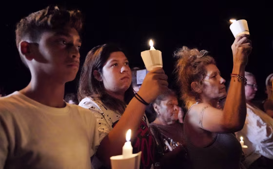 Image: Mourners participate in a candlelight vigil
