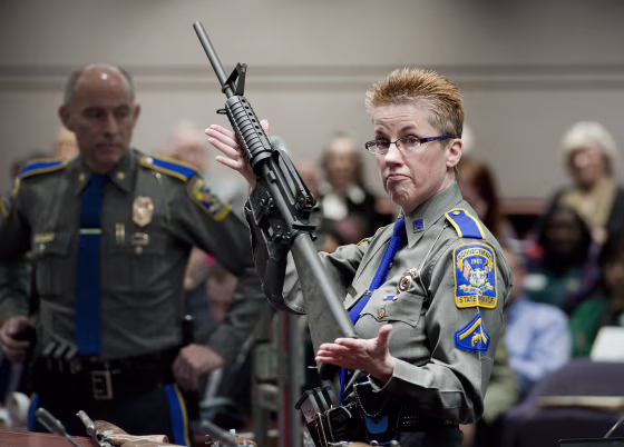 A Connecticut State Police officer holds a Bushmaster AR-15 rifle, the same make and model of the gun used by Adam Lanza, during a hearing reviewing gun laws in Hartford, Connecticut, in 2013.