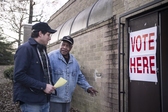 Image: People great each other outside a polling station at the Norwood Community Center in Birmingham, Ala.