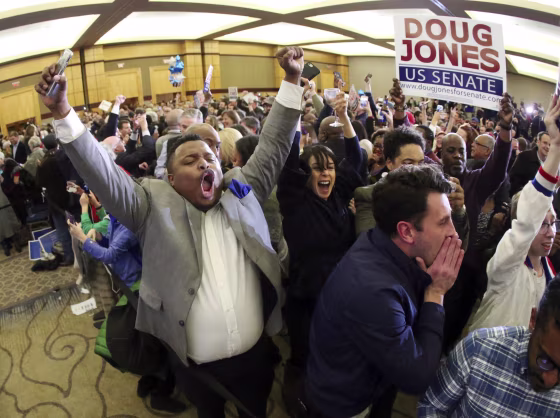 Image: Supporters of Doug Jones erupt is celebration during an election-night watch party