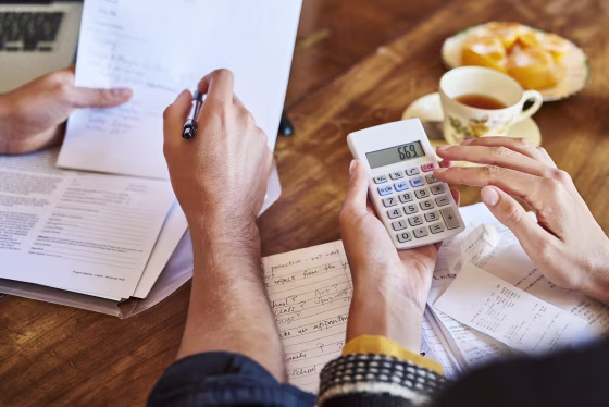 Image: Couple doing paperwork with a calculator at home