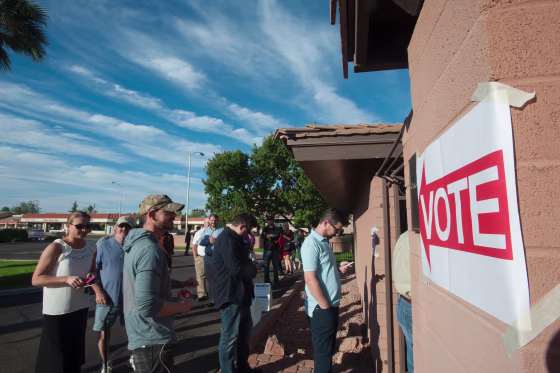 Image: Voters wait in line in front of a polling station  in Scottsdale, Arizona