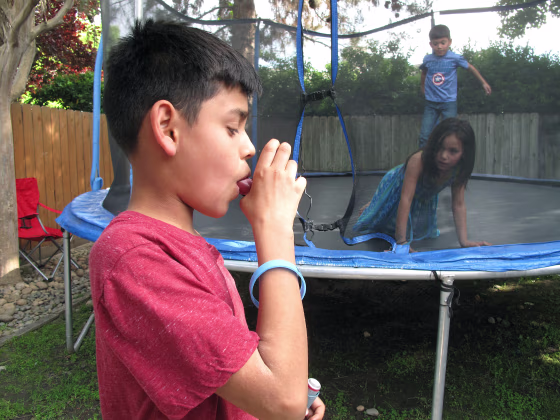 Image: Javier Sua demonstrates how he uses an inhaler