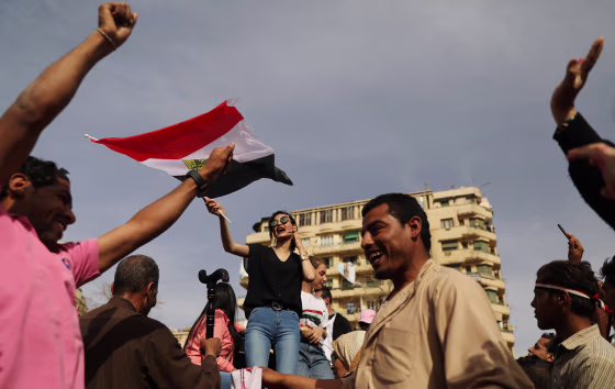 Image: A woman waves an Egyptian flag during the presidential election in Cairo