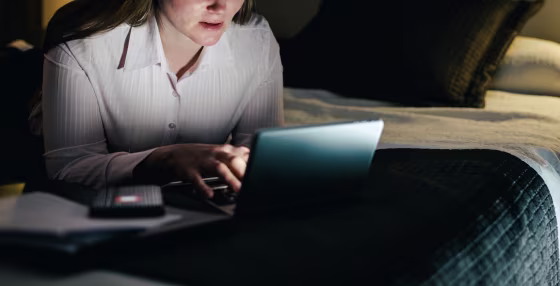 Smiling businesswoman using laptop late.