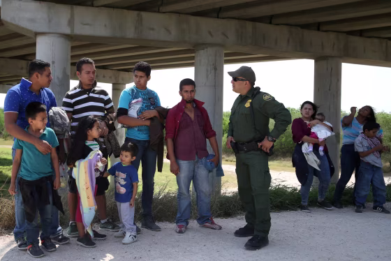Image: A border patrol agent with immigrants who illegally crossed the border from Mexico into the U.S. in the Rio Grande Valley sector, near McAllen