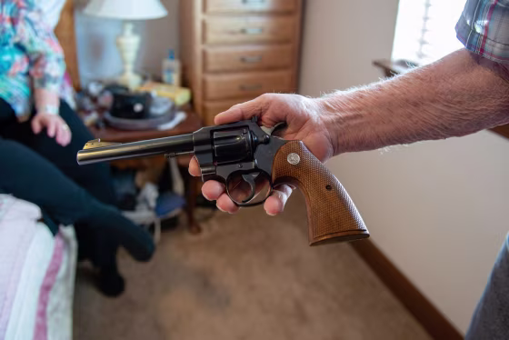 Delmar Scroughams holds a gun from his collection on May 2, 2018.
