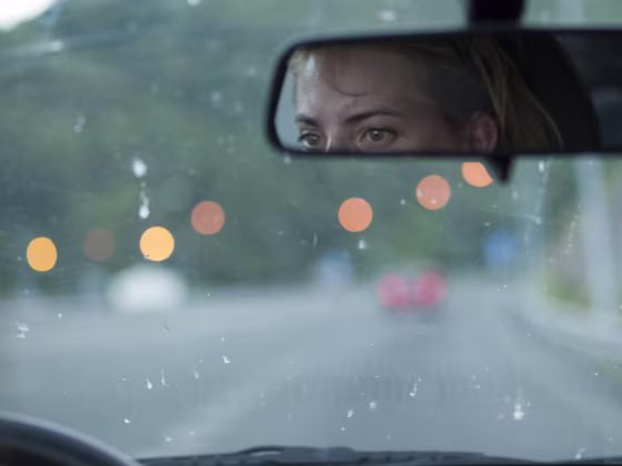Image: Tired woman driving at dusk on a highway