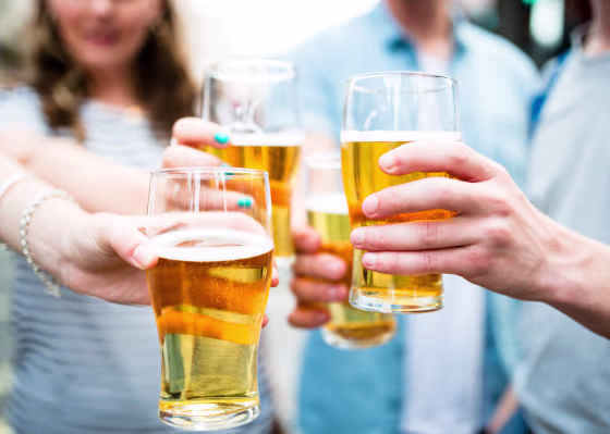 Image: Friends drink pints of beer at Oktoberfest