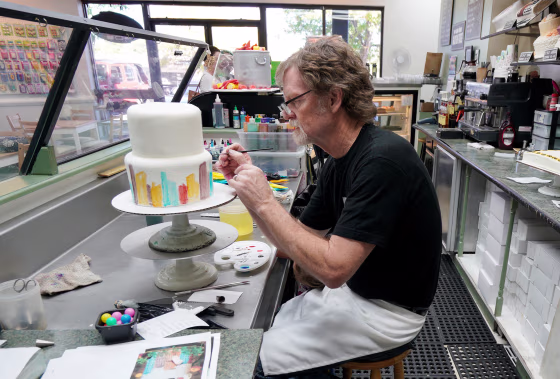 Image: Baker Jack Phillips decorates a cake in his Masterpiece Cakeshop in Lakewood