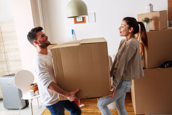 Image: A man and woman carry a box