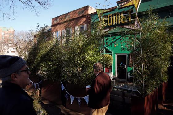 People walk past the Comet Ping Pong pizza restaurant in Washington