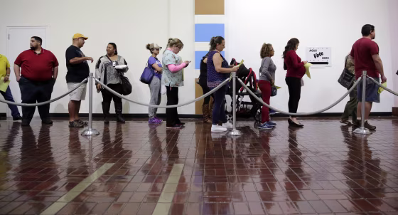 Image: Voters wait in line to cast ballots at an early polling site in San Antonio