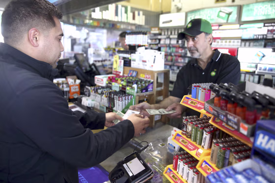 Image: Clerk Zoheir Jendo, right, sells lottery tickets to Jose Reyna of Hampshire at the Stark's Corner Market BP gas station in Pingree Grove, Illinois on Oct. 22, 2018.