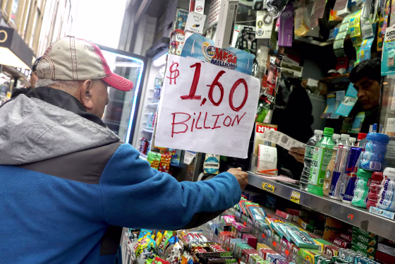 Image: A man buys tickets for Tuesday's Mega Millions lottery drawing after the jackpot exceeded $1.6 billion in New York City