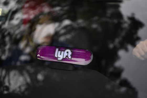 Lyft's new Amp glows on the dashboard of a car