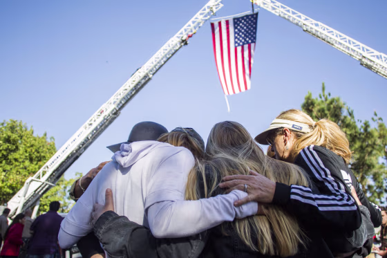 Mourners comfort one another during the procession of Sgt. Ron Helus, who was killed in the shooting at the Borderline Bar and Grill, in Thousand Oaks, California, on Nov. 8, 2018.